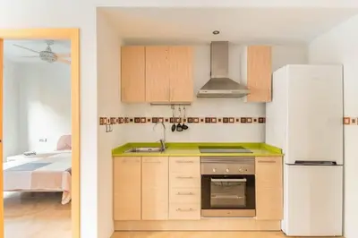 a kitchen with wooden cabinets and a white refrigerator at Lindo y Discreto apartamento playa in Moncófar
