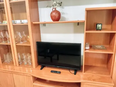 a tv in a wooden book shelf with a television at Apartamento playa de Canet WIFI in Canet de Berenguer
