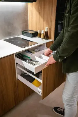 a person reaching into an open drawer in a kitchen at GREEN&FRESH Apartament in Valencia