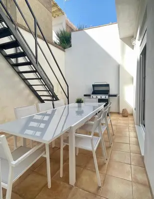 a dining room with a white table and chairs at UIM Mediterraneo CASA Gomez Ferrer Wifi in Puerto de Sagunto