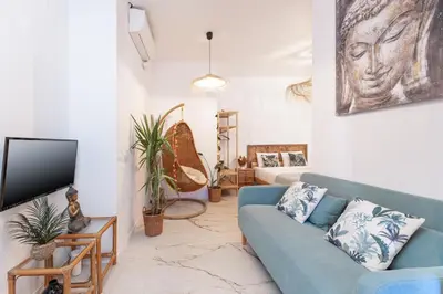 a living room with a blue couch and a tv at SOHO BY THE SEA Valencia in Valencia