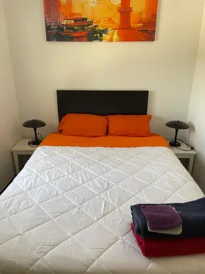a bedroom with a white bed with orange pillows at El Refujio maison independante avec vraie piscine privée au sel chauffee pas de chlore in Turís