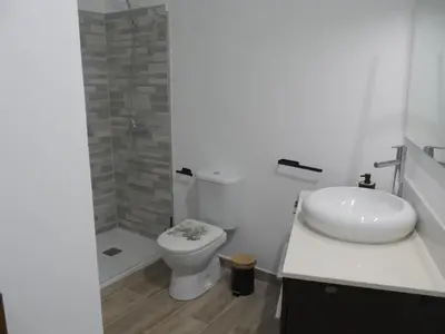 a white bathroom with a toilet and a sink at Casa Vistalmar in Cullera