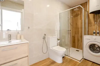 a bathroom with a toilet and a washing machine at NUEVO Apartamentos Costa del Alma in Valencia