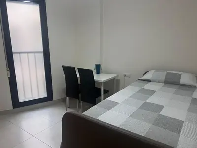 a bedroom with a bed and a table and chairs at APARTAMENTO Playa Patacona VALENCIA in Valencia