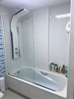 a bath tub with a glass shower in a bathroom at APARTAMENTO Playa Patacona VALENCIA in Valencia