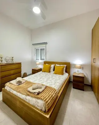 a bedroom with a large bed with yellow pillows at uim mediterraneio PB vicente andres estelles wifi in Puerto de Sagunto