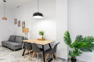 a dining room with a table and chairs and a couch at New Apartment 1 ROOM,4 pax,wifi, ACRuzafa market in Valencia