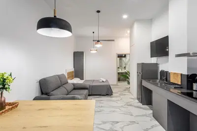 a living room with a couch and a kitchen at New Loft Ruzafa market, wifi AC in Valencia
