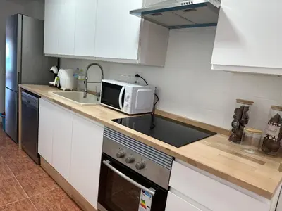 a kitchen with a sink and a microwave at Euromar Playa Cullera frente al mar con garaje in Cullera