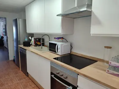 a kitchen with a sink and a microwave at Euromar Playa Cullera frente al mar con garaje in Cullera