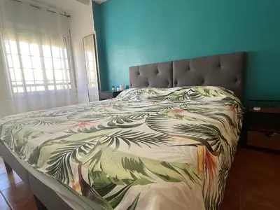a bed in a bedroom with a bedspread with leaves at Valencia nuevo centro in Valencia