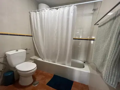 a bathroom with a toilet and a shower curtain at Valencia nuevo centro in Valencia