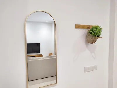 an arch mirror in a bathroom with a tv at VLC HOST - Alfaro A in Valencia