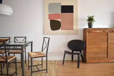 a dining room with a table and chairs and a painting at Stylish well-connected beachfront flat in Valencia