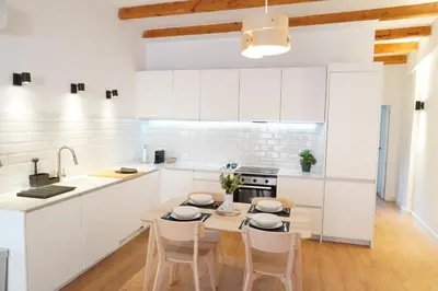 a white bedroom with a large bed with a window at Apartamento Ático en Valencia in Valencia