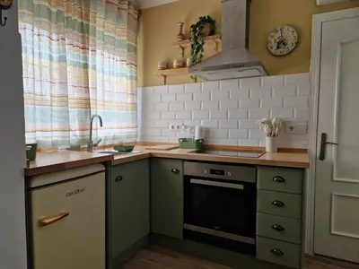 a small kitchen with green cabinets and a sink at Ca les Rinconetes in Riola