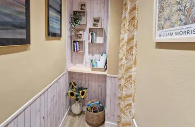 a hallway with a shelf and a vase with flowers at Ca les Rinconetes in Riola