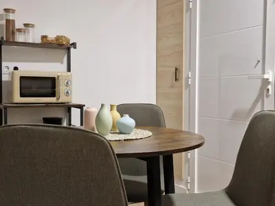 a dining room with a table and chairs and a microwave at Ca les Rinconetes in Riola