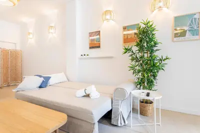 a living room with a bed and a potted plant at Julio's Apartment in Valencia
