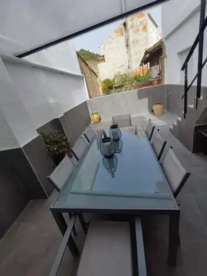 a glass table and chairs on a balcony at Casa Salvador, Escapada de Aventura y Relax en Buñol in Buñol