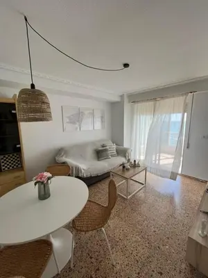 a living room with a bed and a table and chairs at Caballito de Mar in Tavernes de Valldigna