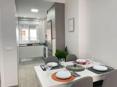 a dining room with a white table and chairs at Seahorse apartment El Perelló in El Perelló