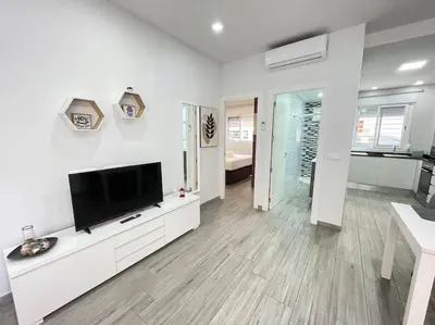 a white living room with a flat screen tv at Seahorse apartment El Perelló in El Perelló
