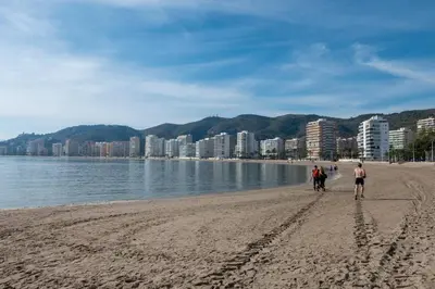 a group of people walking on the beach at Apartamento Arenal 1a Linea de Playa in Cullera