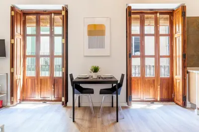 a dining room with a black table and wooden doors at Modern Flat by Mercado Central in Ciutat Vella in Valencia