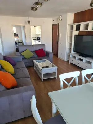 a living room with a couch and a tv at Apartamento en complejo residencial con piscina in Puebla de Farnals