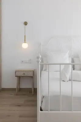 a white bedroom with a bed and a table at ApartUP Ca La Leni Beach II in Valencia