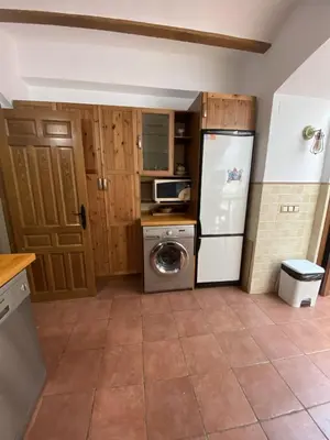 a kitchen with a refrigerator and a washing machine at Casa Rural El Molino in Macastre
