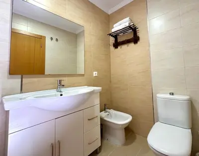 a bathroom with a sink and a toilet and a mirror at Vacaciones con el Mediterráneo a menos de 50 metros in Cullera