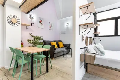 a bedroom and a living room with a table and chairs at Marie Curie Flats, Lovely Loft in Valencia