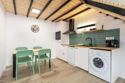 a kitchen with a table and chairs and a washing machine at Marie Curie Flats, Lovely Duplex 2 in Valencia