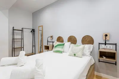 a white bedroom with a large white bed with pillows at Marie Curie Flats, Lovely Duplex 2 in Valencia