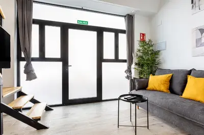 a living room with a gray couch and yellow pillows at Marie Curie Flats, Lovely Duplex 2 in Valencia