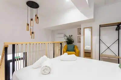 a bedroom with a white bed and a yellow chair at Marie Curie Flats, Lovely Duplex 3 in Valencia