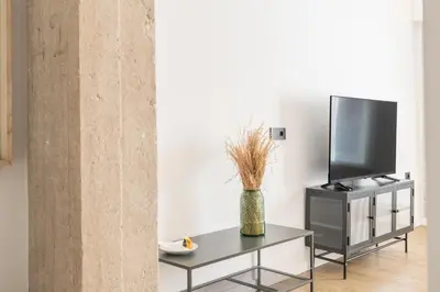 a living room with a tv and a vase on a table at Guastavino by Alma Suites in Valencia