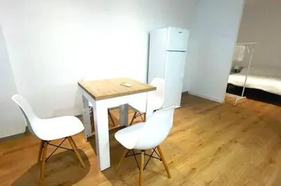 a small table with two white chairs and a refrigerator at Apartamento Cienciasmar in Valencia