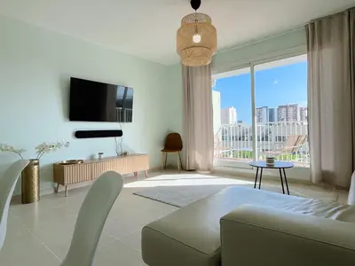 a living room with a tv and a large window at Marinao Apartment in Playa Pobla de Farnals