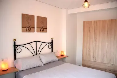 a bedroom with a bed and two lights on the wall at Casa Rural Buñol Ca Maruja-Experiencia Unica in Buñol