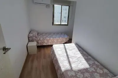 a small room with two beds and a window at Apartamento en Cullera in Cullera