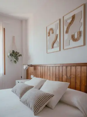 a bedroom with a white bed with two pictures on the wall at Casa Marla, Siete Aguas in Siete Aguas