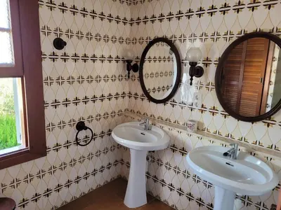 a bathroom with two sinks and two mirrors at La Casa del Sol in La Eliana