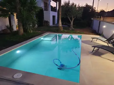a swimming pool with a hose in the middle of a house at La Casa del Sol in La Eliana