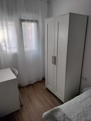 a bedroom with a white cabinet next to a bed at Casa Bonita de Gisela in Puerto de Sagunto