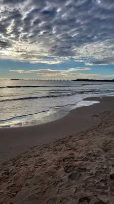 a beach with a cloudy sky and the ocean at Casa Bonita de Gisela in Puerto de Sagunto