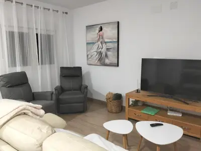 a living room with a couch and a flat screen tv at Casa Bonita de Gisela in Puerto de Sagunto